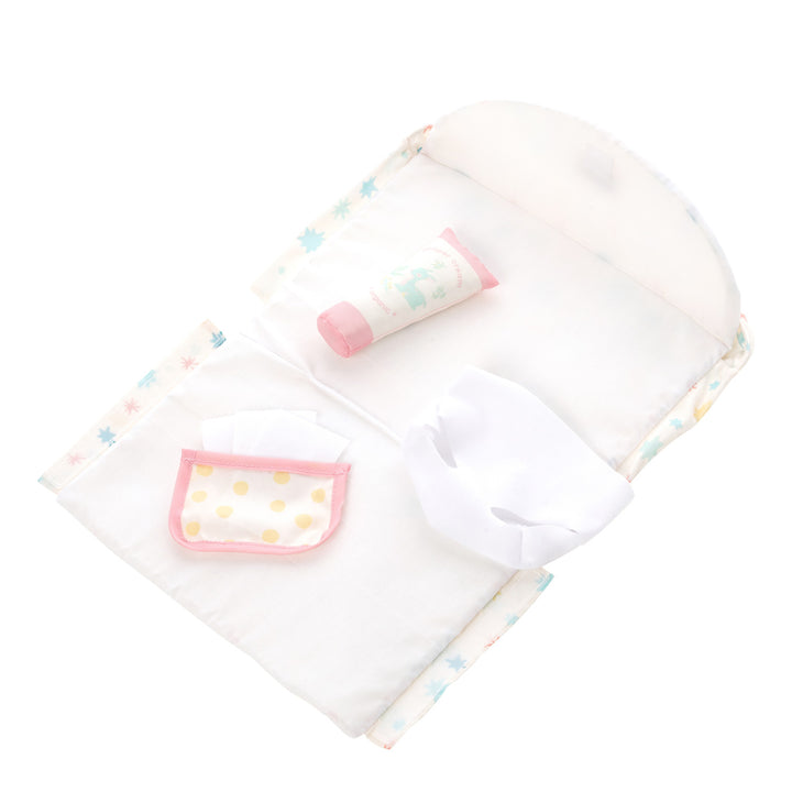 baby doll diaper bag folded open into a changing mat with diaper, wipes and diaper cream tube laid on top