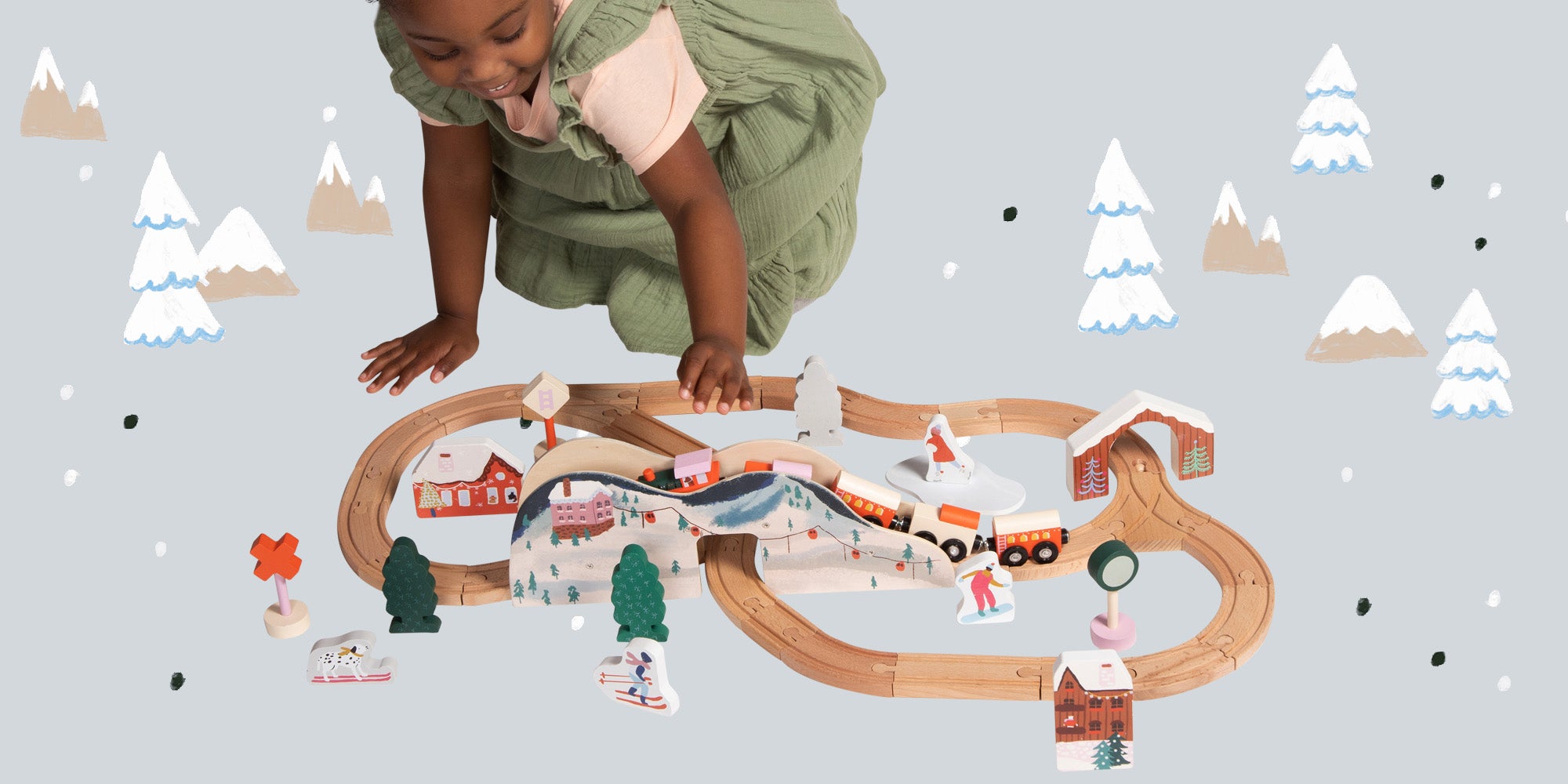 preschool age girl playing with winter themed train set