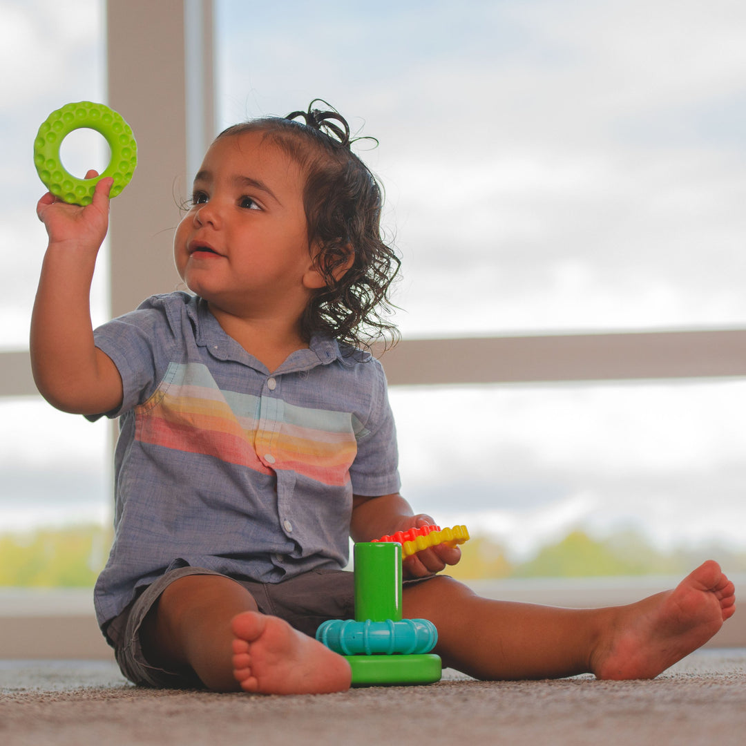 little boy playing with small ring stacker toy