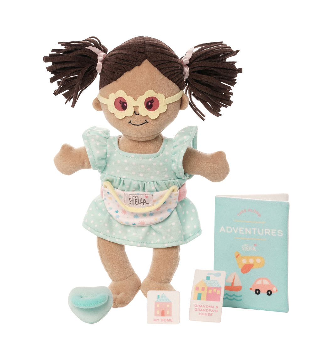 travel themed doll accessory set with doll sized fanny pack and sunglasses show on a soft doll along with a child sized travel book with 6 stamps 